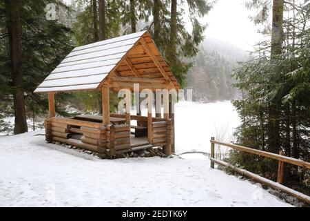 Holzpavillon im Winterwald Stockfoto