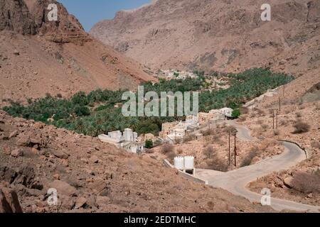 Arabisches Bergdorf Harat Bidih in der Schlucht des Wadi Tiwi, Oman. Oase in einem trockenen, tiefen Wüstental. Stockfoto