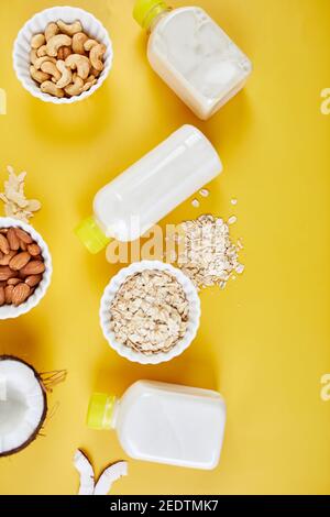 Alternative Arten von veganen Milch in Flaschen auf einem gelben Hintergrund Stockfoto