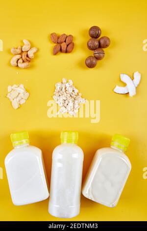 Alternative Arten von veganen Milch in Flaschen auf einem gelben Hintergrund Stockfoto