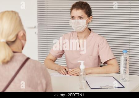 Porträt der jungen Ärztin mit Maske beim Beratungsbesuch in der Klinik oder im medizinischen Zentrum, kopieren Raum Stockfoto
