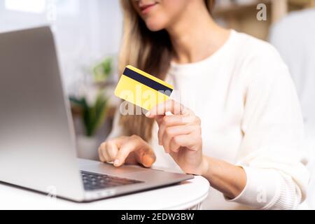 Frau, die mit Laptop und Kreditkarte einkaufen Stockfoto