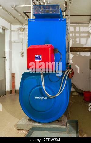 Alte blaue Buderus G 105 Öl-Heizkessel mit rot Strahlungsbrenner aus dem Jahr 1992 Stockfoto