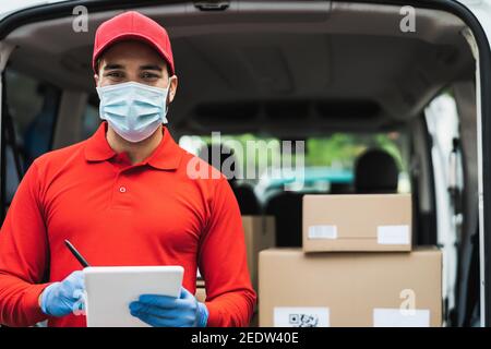 Delivery Mann trägt Gesichtsschutzmaske, um Corona-Virus zu vermeiden Spread - Junge Express-Kurier arbeitet während Coronavirus Ausbruch Stockfoto