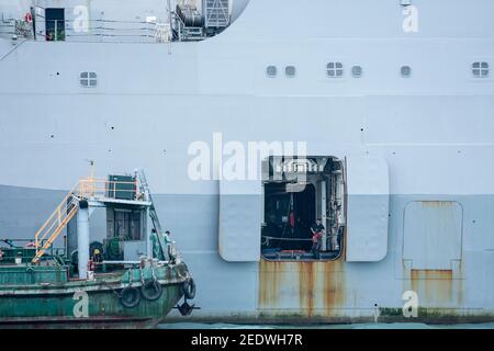 Blick auf das Amphibiendock-Landungsschiff USS Green Bay (LPD 20) vor der Skyline von Gebäuden, angedockt am Eingang zum Victoria Harbour im Rahmen eines planmäßigen Hafenbesuchs. Green Bay ist Teil der Bonhomme Richard Expeditionary Strike Group, die hier in Hongkong, Hongkong, SAR, China, VR China, zu sehen ist. © Time-Snaps Stockfoto