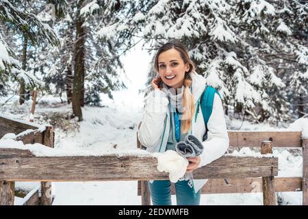 Frau, die sich während der Wanderung im Winter und im Schnee ausruhen kann Stockfoto