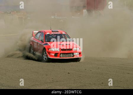 Rally Car auf einem Schleuder auf einer staubigen Rennstrecke und hinterlässt eine Staubwolke hinter sich. Stockfoto