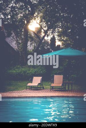 Sonnenliegen am Pool bei Abendlicht. Stockfoto