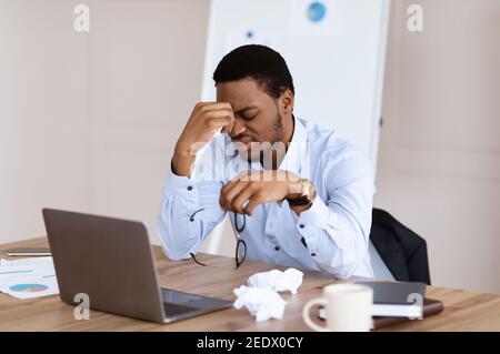 Erschöpfter afroamerikanischer Manager, der an Burnout leidet Stockfoto