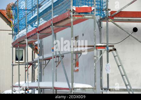 Machern, Deutschland. Februar 2021, 13th. Das Gerüst auf einer Baustelle für ein Einfamilienhaus im Leipziger Stadtteil ist schneebedeckt und die Bauarbeiten sind ruhig. Quelle: Volkmar Heinz/dpa-Zentralbild/ZB/dpa/Alamy Live News Stockfoto