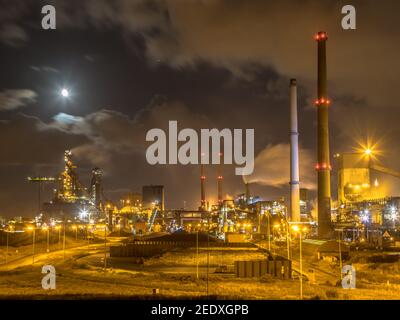 Stahlfabrik in der Nacht unter Vollmond. Schwerindustrie Szene in Velsen Noord. Niederlande. Stockfoto