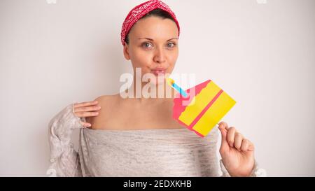 Porträt einer Frau, die eine Kerze auf einem gefälschten Pappkuchen ausbläst. Stockfoto