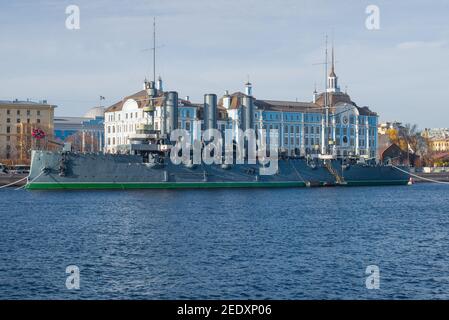 ST. PETERSBURG, RUSSLAND - 25. OKTOBER 2019: Cruiser 'Aurora' vor dem Hintergrund des Gebäudes der Nakhimov Naval School am Oktobernachmittag Stockfoto