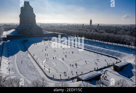 Leipzig, Deutschland. Februar 2021, 14th. Mit und ohne Schlittschuhe und alle Arten von Wintersportgeräten sind die Leipzigers auf dem Tränensee vor dem Völkerschlachtdenkmal unterwegs. Nach frostfreien Tagen laden zumindest die flachen Teiche zum Eislaufen ein. (Luftaufnahme mit Drohne) Quelle: Jan Woitas/dpa-Zentralbild/ZB/dpa/Alamy Live News Stockfoto