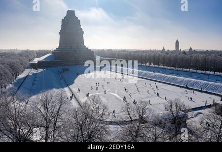 Leipzig, Deutschland. Februar 2021, 14th. Mit und ohne Schlittschuhe und alle Arten von Wintersportgeräten sind die Leipzigers auf dem Tränensee vor dem Völkerschlachtdenkmal unterwegs. Nach frostfreien Tagen laden zumindest die flachen Teiche zum Eislaufen ein. (Luftaufnahme mit Drohne) Quelle: Jan Woitas/dpa-Zentralbild/ZB/dpa/Alamy Live News Stockfoto