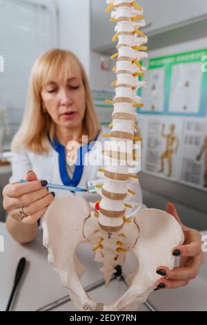 Arzt Physiotherapeut erklärt den Mechanismus der Verletzung mit Hilfe der Wirbelsäule Modell Stockfoto