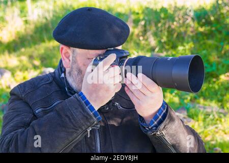 Nahaufnahme eines älteren Mannes, der ein Foto in der Natur gemacht hat. Konzept des Genießens in der Natur Stockfoto
