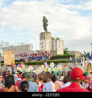 Mai-Feier in Kuba: Che Guevara Statue mit einer Menge, die vorne in rot, weiß und blau steht und Smiley-Gesichtsschilder hält. Stockfoto