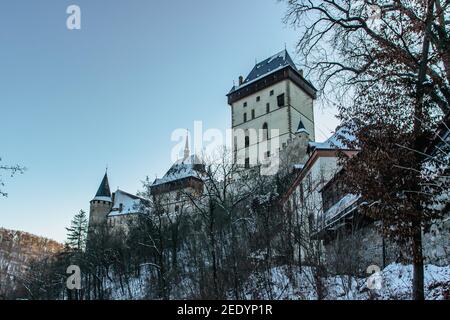 Schöne gotische königliche Burg Karlstejn im Winter mit Schnee, Tschechische Republik.gegründet von Karl IV. Es gibt tschechische Kronjuwelen, heilige Reliquien und königliche Stockfoto