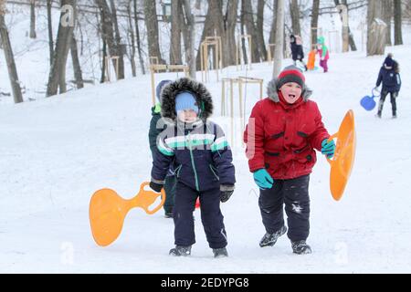 Nicht exklusiv: DNIPRO, UKRAINE - 13. FEBRUAR 2021 - Kinder klettern einen Hügel im Zelenyi Hai Park, Dnipro, Zentralukraine. Stockfoto