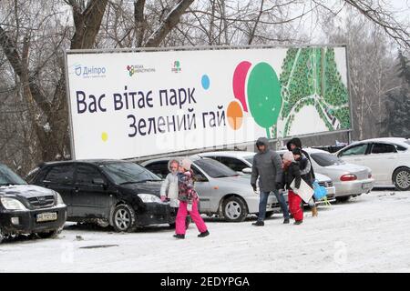 Nicht exklusiv: DNIPRO, UKRAINE - 13. FEBRUAR 2021 - Kinder und Erwachsene überqueren einen Parkplatz am Zelenyi Hai Park, Dnipro, Zentralukraine. Stockfoto