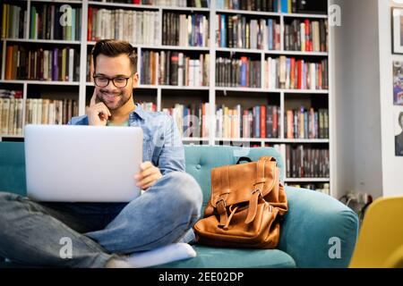 Der Schüler bereitet die Prüfung und den Lernunterricht in der Schulbibliothek vor Stockfoto