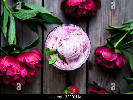 Eis und Pfingstrose Blume als Symbol des Sommers und Urlaub auf Holz Hintergrund A Stockfoto