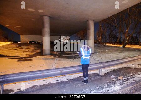 Berlin, Deutschland. Februar 2021, 12th. Antonia steht unter einer Brücke mit heißer Suppe in der Hand und wartet auf Obdachlose, die ihnen ihre Suppe geben. Am selben Tag fuhren drei Mitarbeiter der Stadtmission mit dem kalten Bus durch die Stadt und halfen Obdachlosen. Sie verteilten Schlafsäcke, Nahrung und Handschuhe. Im Winter sind in Berlin mehrere Kaltbusse für Obdachlose im Einsatz. Quelle: Annette Riedl/dpa/Alamy Live News Stockfoto