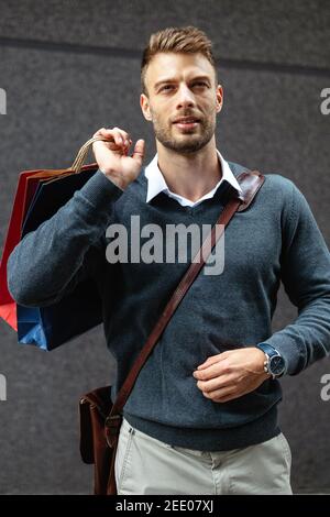 Stattliche attraktiver Mann lächelnd Shopping in der Stadt Stockfoto
