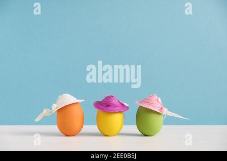 Positive Freundinnen. Glückliche Eier in Hüten. Osterfeiertagskonzept mit niedlichen lustigen Eiern. Verschiedene Emotionen und Gefühle Stockfoto