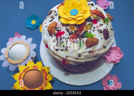 russische osterkuchen mit Papierblumen über traditionellen kandierten dekoriert Früchte Nüsse und weiße Zuckerguss Stockfoto