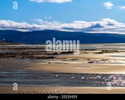 Der Sandstrand von Barmouth Bay oder Abermaw in Gwynedd an der Nordwestküste von Wales mit den Bergen von Snowdonia in der Ferne. Stockfoto