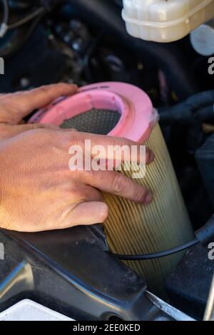 Eine Nahaufnahme der Hände eines kaukasischen männlichen Autos Mechanisches Wechseln des Luftfilters in einem Motor Stockfoto