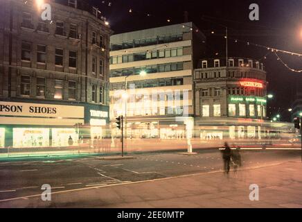 1975 Shefffield - Verkehr an der Kreuzung von Pinstone Street und Leopold Street Sheffield City Centre. WILSON PECK, „die Heimat der Musik“, hat die Ehre, Sheffield’s längster Plattenladen zu sein. Es war 1896 geöffnet, und die beiden Gründer Arthur Wilson (ein Pseudonym) und John Peck waren schon seit einigen Jahren im Geschäft mit dem Verkauf von Klavieren. Es ist jetzt H L Brown Jewelers.Timpson Schuhe besetzten das Gebäude gegenüber, jetzt Barclays Bank, aber früher Wilson Peck! Sheffield City Centre South Yorkshire England GB Großbritannien Europa Stockfoto