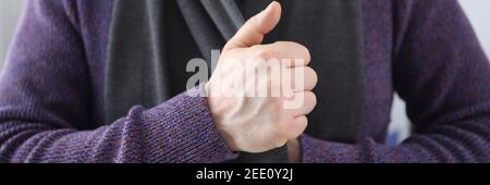 Mann in Strickpullover Puting auf warmen Schal Nahaufnahme Stockfoto