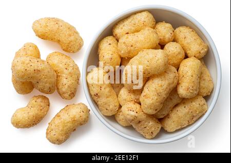 Erdnussflips in einer weißen Keramikschale neben einigen Erdnussflips isoliert auf weiß. Draufsicht. Stockfoto