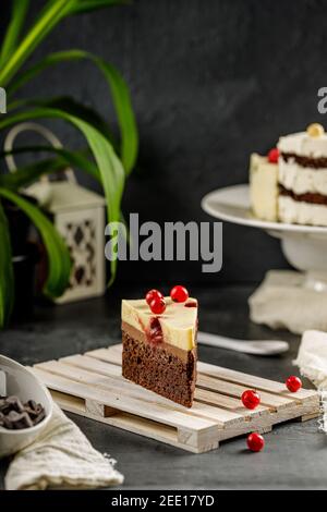 Nahaufnahme eines Stücks köstlicher Kuchen mit roter Johannisbeere und kitschiger Schlagsahne. Leckerer Käsekuchen Stockfoto