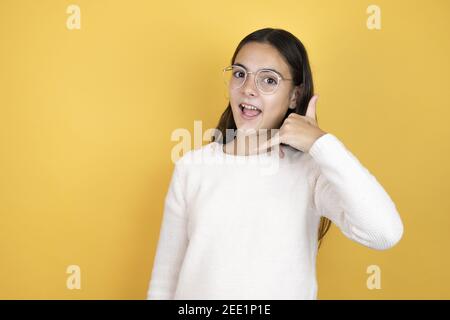 Schöne Kind Mädchen tragen lässige Kleidung lächelnd dabei Telefon Geste Mit Hand und Fingern sprechen Sie gerne am Telefon Stockfoto