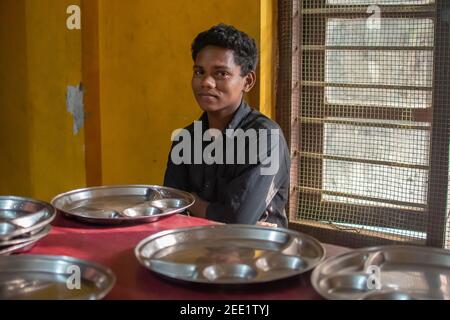 Kerala. Indien. 05-20-2018. Ein männlicher Jugendlicher ruht sich nach dem Mittagessen in seiner Schule aus. Stockfoto