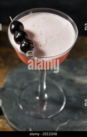 Erfrischender, spritzig-rosafarbener Cocktail mit Gin und Kirschen Stockfoto