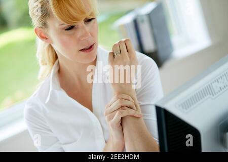 Frau hält ihr schmerzhaftes Handgelenk Stockfoto