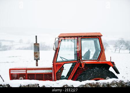 Roter Traktor im Schnee, Fintry, Schottland. Stockfoto