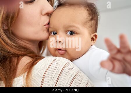 Niedlich liebenswert afrikanisch amerikanisch Baby Tochter mit Spaß in Mütter Arme. Stockfoto