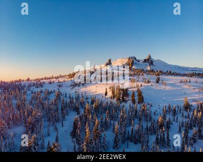 Bunte Winter Sonnenuntergang in Sheregesh Skigebiet Berge mit Wolken. Luftaufnahme Draufsicht Wald Russland. Stockfoto