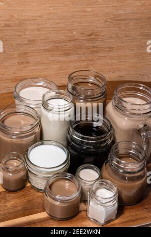 Eine konzeptuelle Aufnahme mit Milch/Tee/Kaffee in Tassen, die in einer Weise angeordnet sind, die einen Farbverlauf erzeugt. Kaffeetönen. Stockfoto