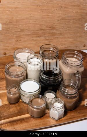 Eine konzeptuelle Aufnahme mit Milch/Tee/Kaffee in Tassen, die in einer Weise angeordnet sind, die einen Farbverlauf erzeugt. Kaffeetönen. Stockfoto