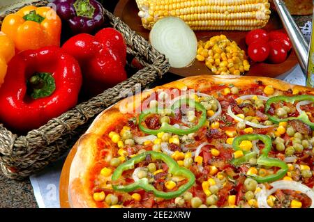 Pizza mit Mais, Speck, Paprika, Zwiebeln, Erbsen Stockfoto