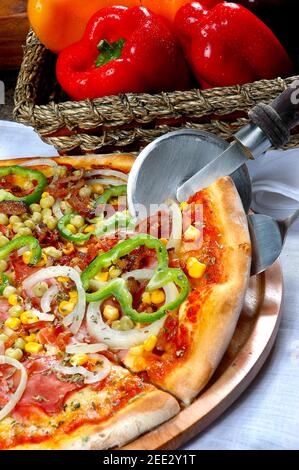 Pizza mit Mais, Speck, Paprika, Zwiebeln, Erbsen Stockfoto