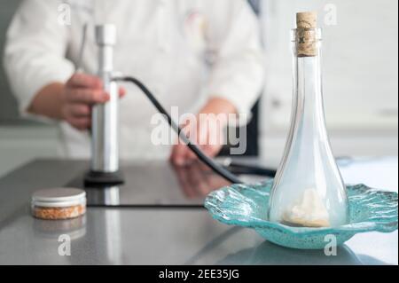 Feiner Restaurantkoch, raucht einen Teller mit raffinierten Küchenutensilien. Hochwertige Fotos. Stockfoto