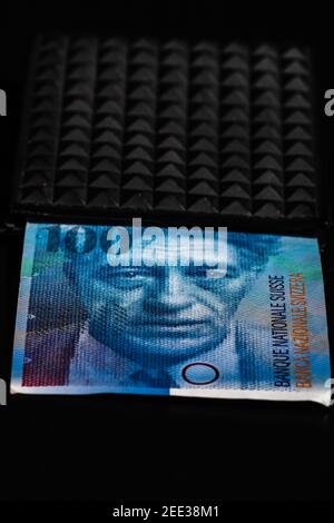 100 schweizer Franken Banknote in einer schwarzen Geldbörse isoliert. Stockfoto